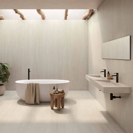 Casa de banho luxuosa com o cerâmico Serena Veincut Bone aplicado no pavimento e nas paredes, com uma banheira oval branca.